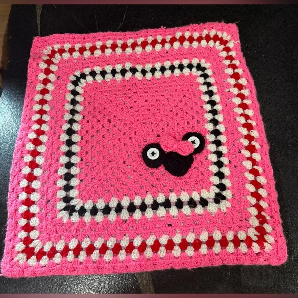 This is a handmade crocheted Minnie Mouse granny square blanket.